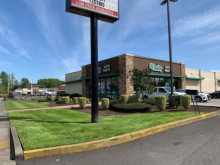 Manicured commercial lawn with shrubs and dark mulch