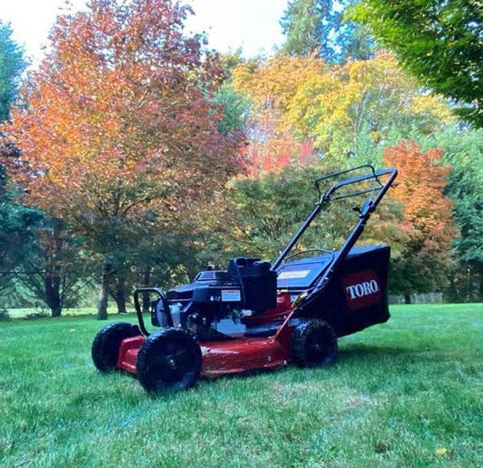 Toro mower on lawn with fall foliage